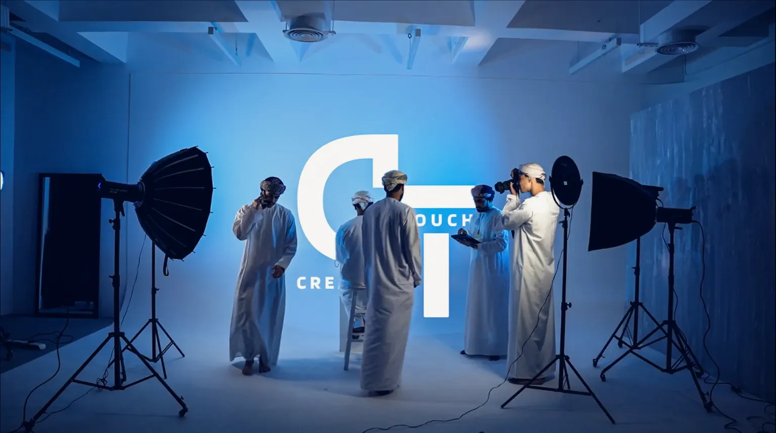 Studio photoshoot in blue light in front of the projected Creative Touch logo